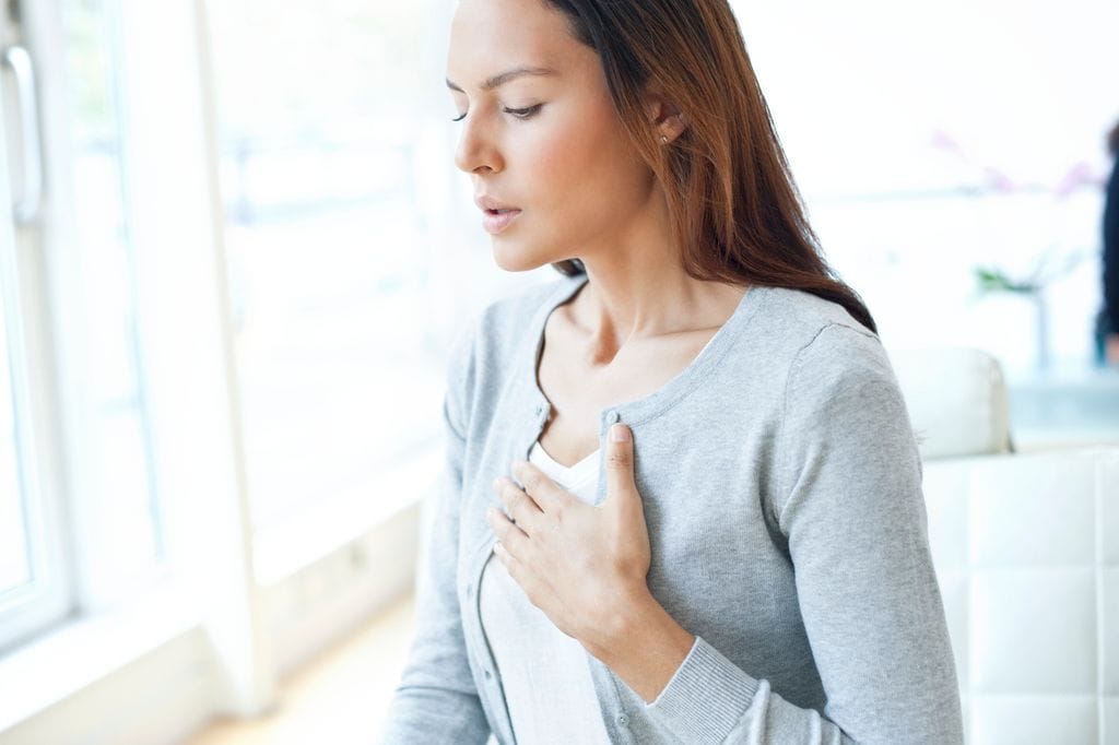 mujer con dolor en el pecho