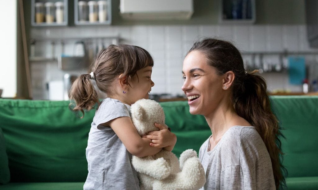 smiling young mum talking with little daughter