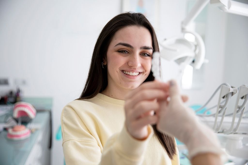 mujer con una férula de descarga en el dentista