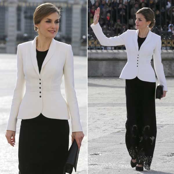 La Reina, con el pelo recogido, ha elegido un elegante vestido negro conjuntado con un blazer en color blanco
