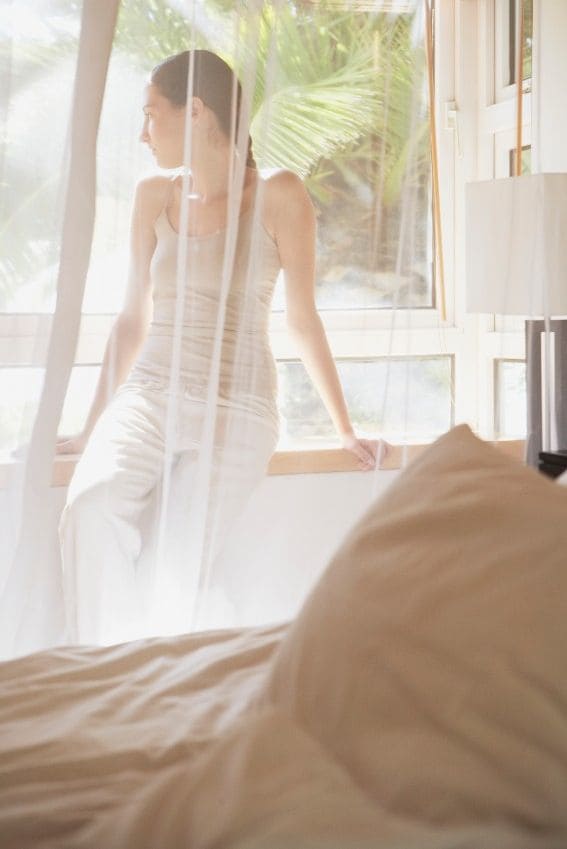 Mujer sentada en una habitación con mosquitera