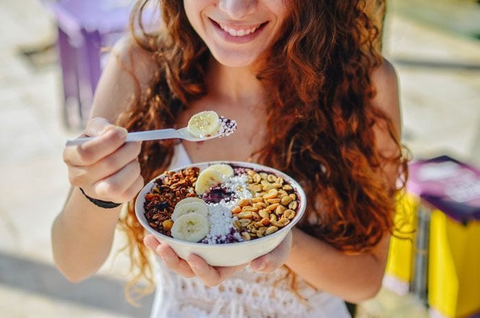 mujer tomando un bowl de acai