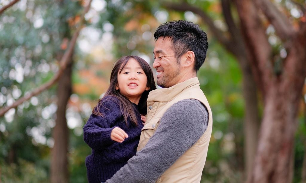 father embracing daughter in park