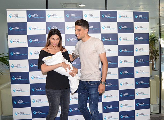 Melissa Jiménez y Marc Bartra posan sonrientes a la salida del hospital con su pequeña Abril