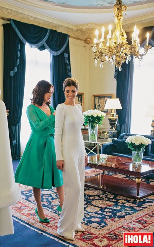 Carmen Martínez-Bordiú ayuda a su hija con los últimos retoques de su original mono de Pronovias, que se completaba con un abrigo, también de crepé y ribeteado con piel de zorro, que se ve en la imagen se puede ver colgado a la izquierda
