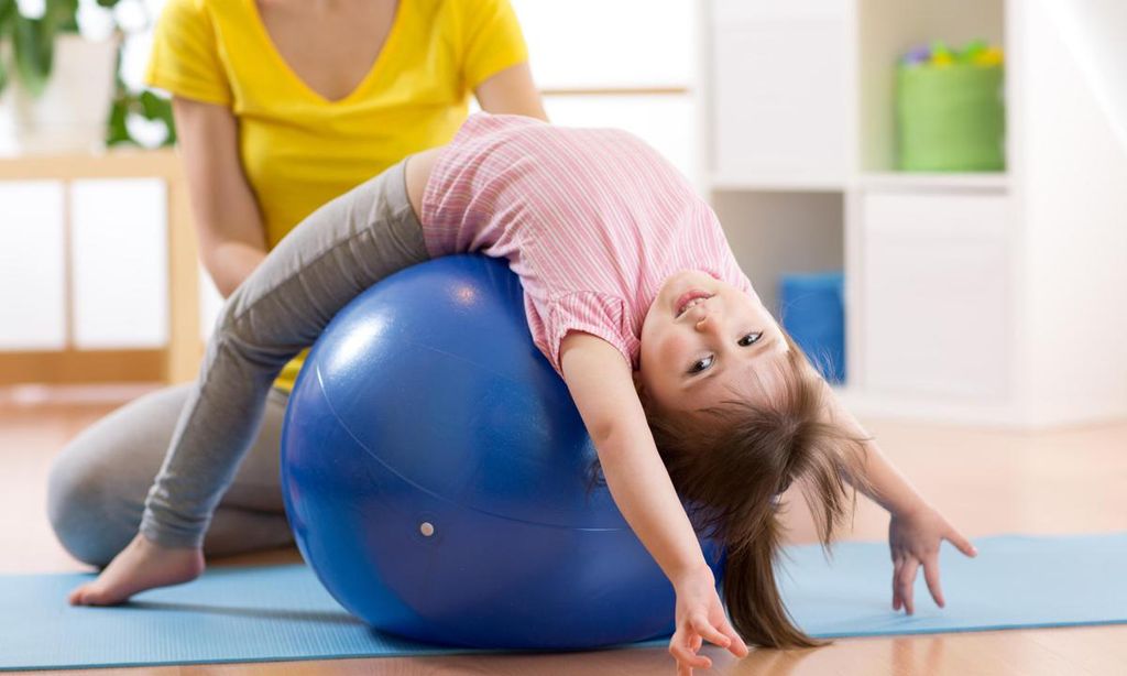 ni a haciendo ejercicios en una pelota de pilates