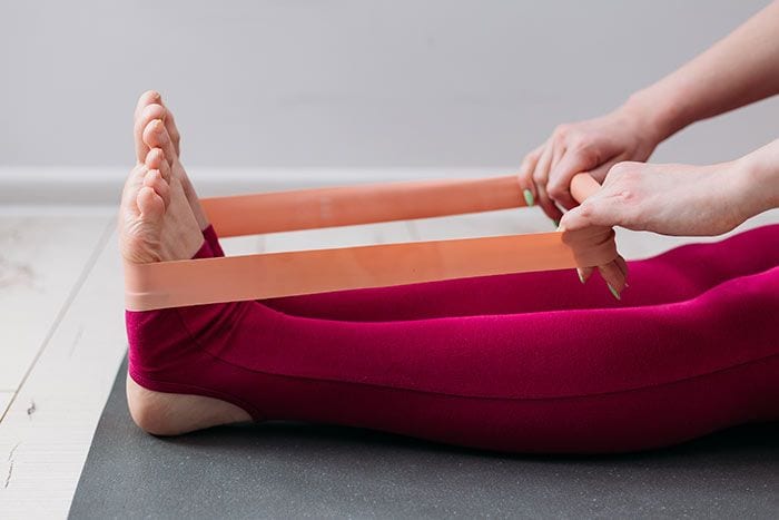 mujer entrenando con una goma elástica