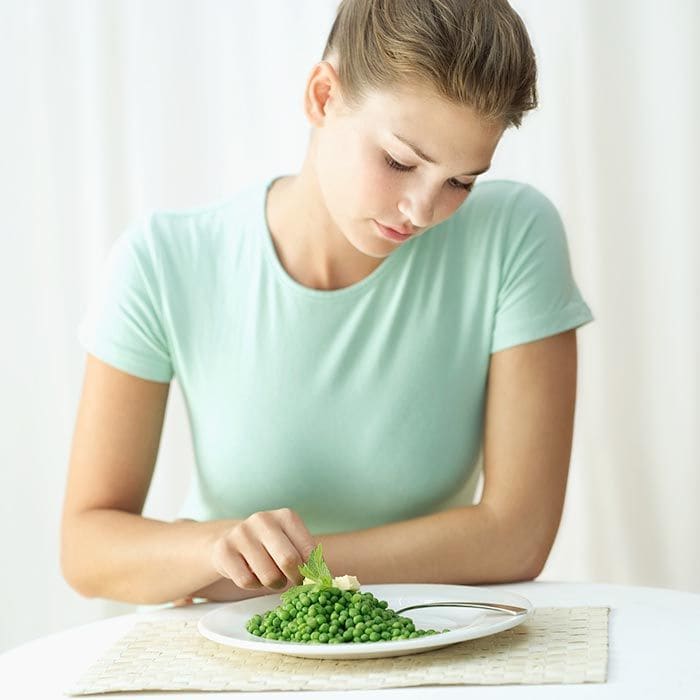 mujer comiendo guisantes