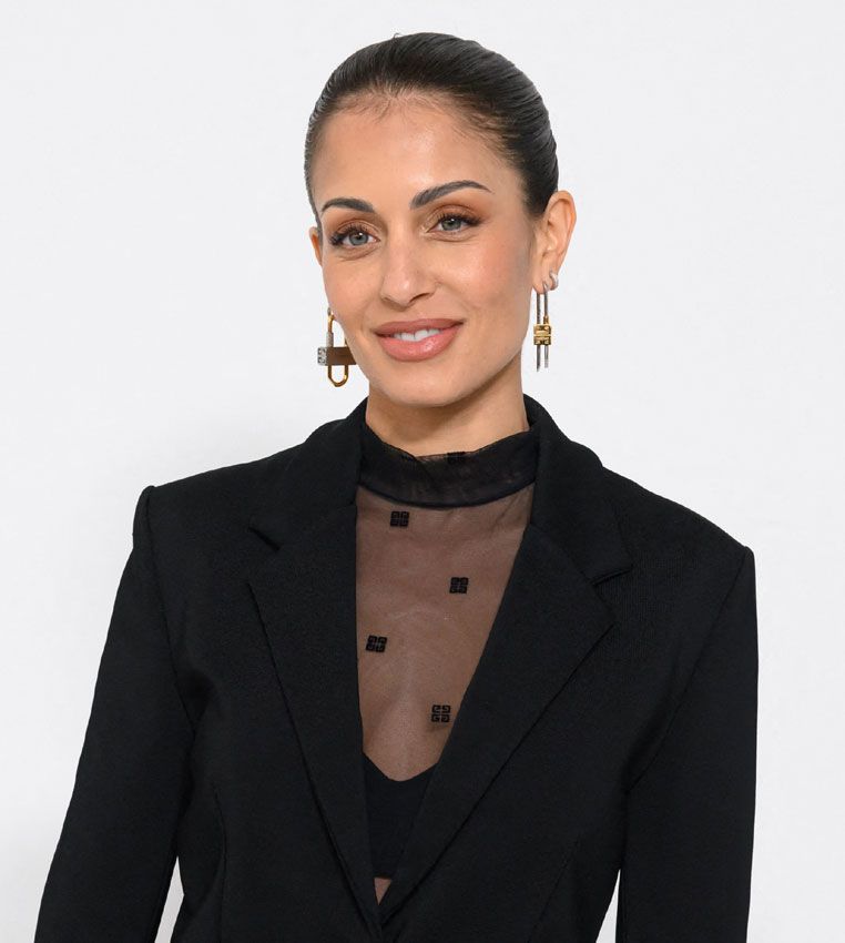 Hiba Abouk y su look de traje negro en el desfile de Givenchy