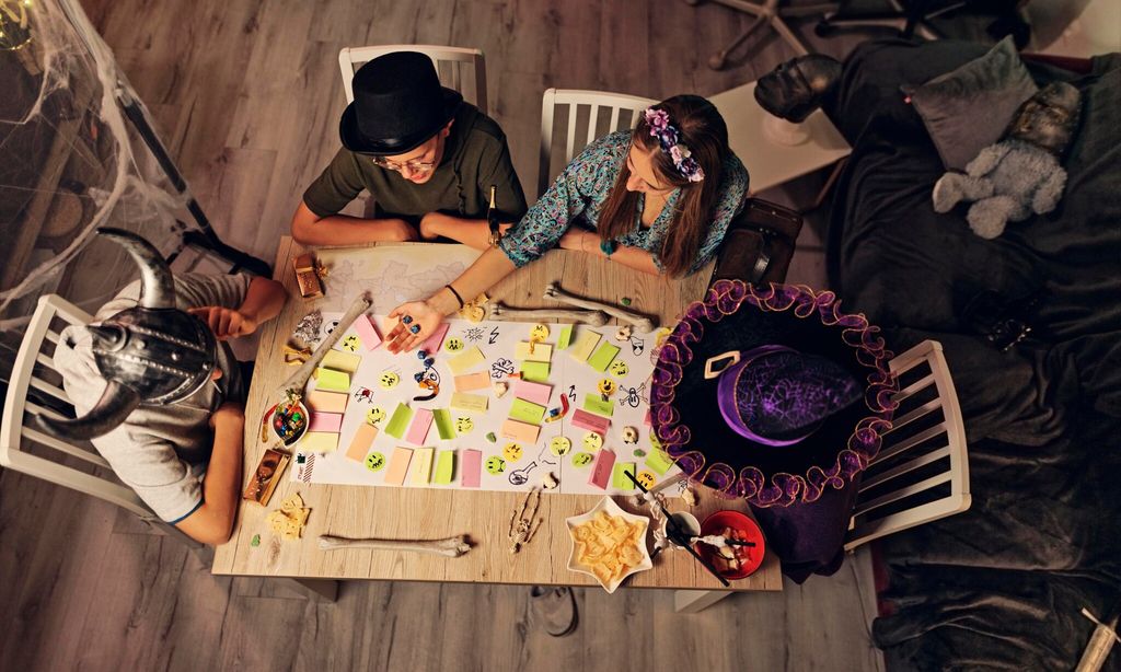 family playing custom board rpg game together at home 