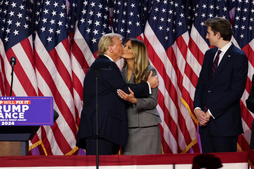 El beso de la victoria entre Donald y Melania Trump, mientras su único hijo, Barron, los observa