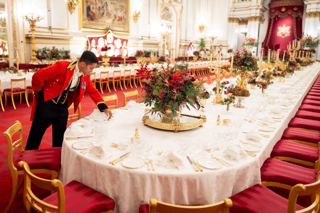 Un lacayo senior aplica los toques finales a las mesas del salón de baile del Palacio de Buckingham, Londres, antes del Banquete Estatal para el Emir de Qatar y su esposa en el Palacio de Buckingham en Londres 