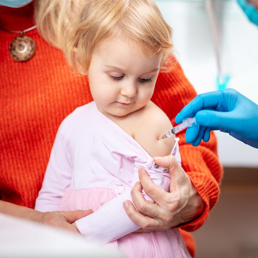 Pediatra vacuna a una niña