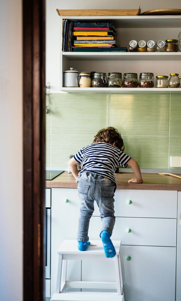 Niño trepando a un taburete