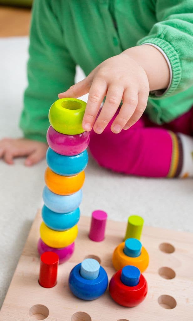 Niño haciendo torre con bloques de madera