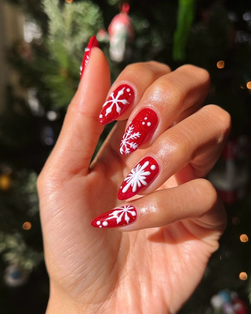 Manicura navideña roja con dibujos de copos de nieve