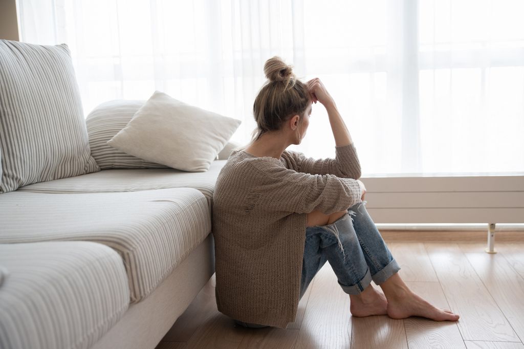 mujer deprimida sentada en el suelo