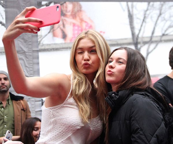 La 'top' Gigi Hadid, posa divertida en un 'selfie' con una fan.
