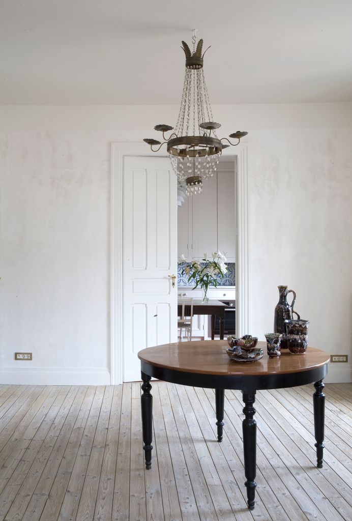 Rincón con mesa redonda de madera y lámpara de techo de cristal