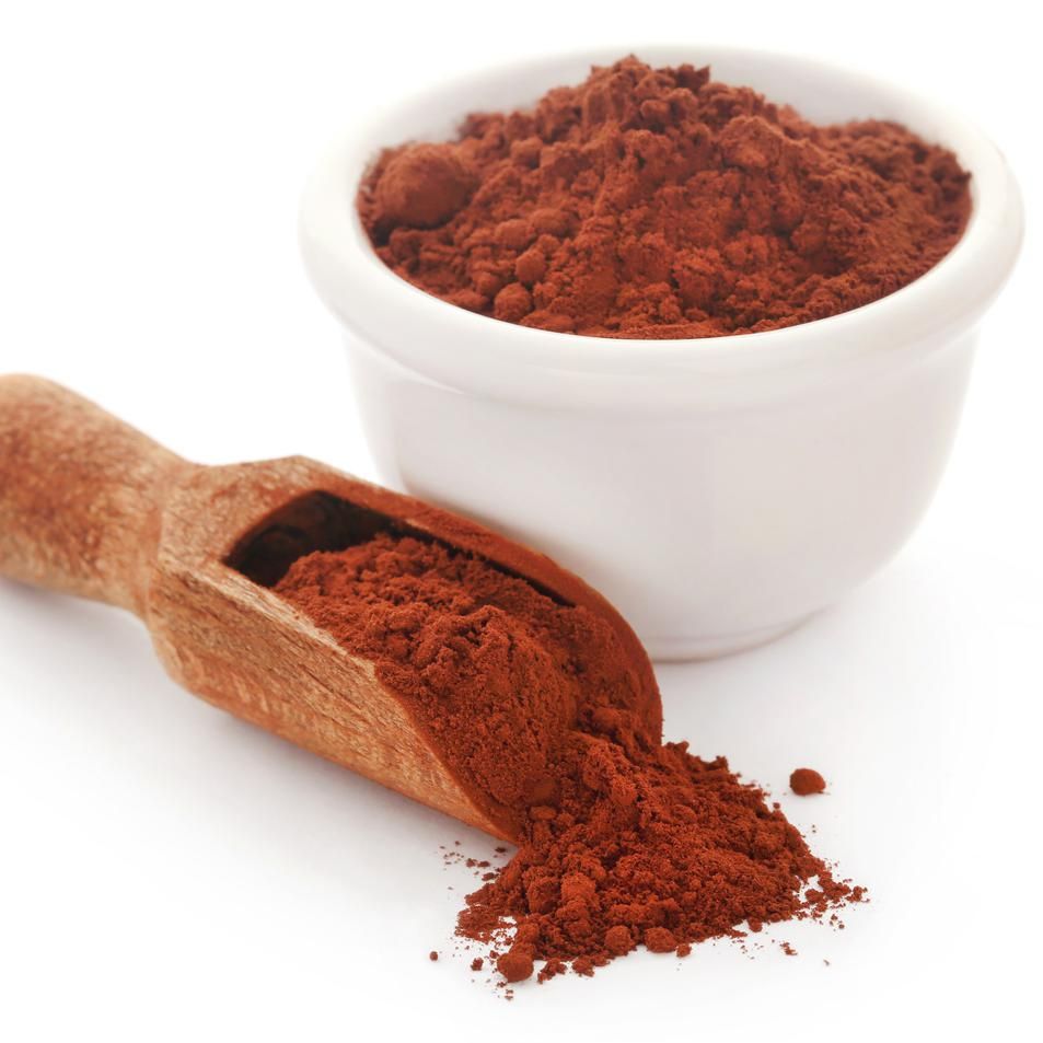 polvo de cacao en cuchara de madera y recipiente