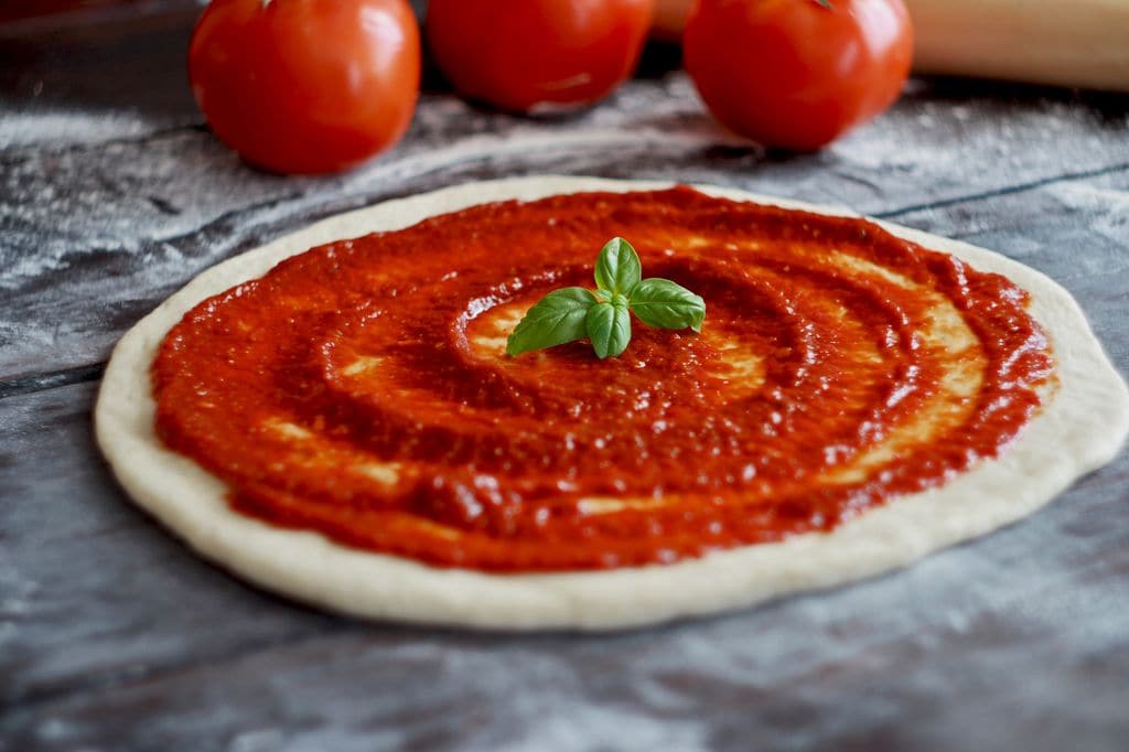 Masa de pizza casera con salsa de tomate 