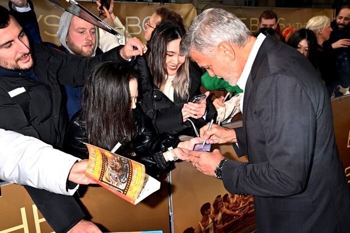 George Clooney firma autógrafos a los fans