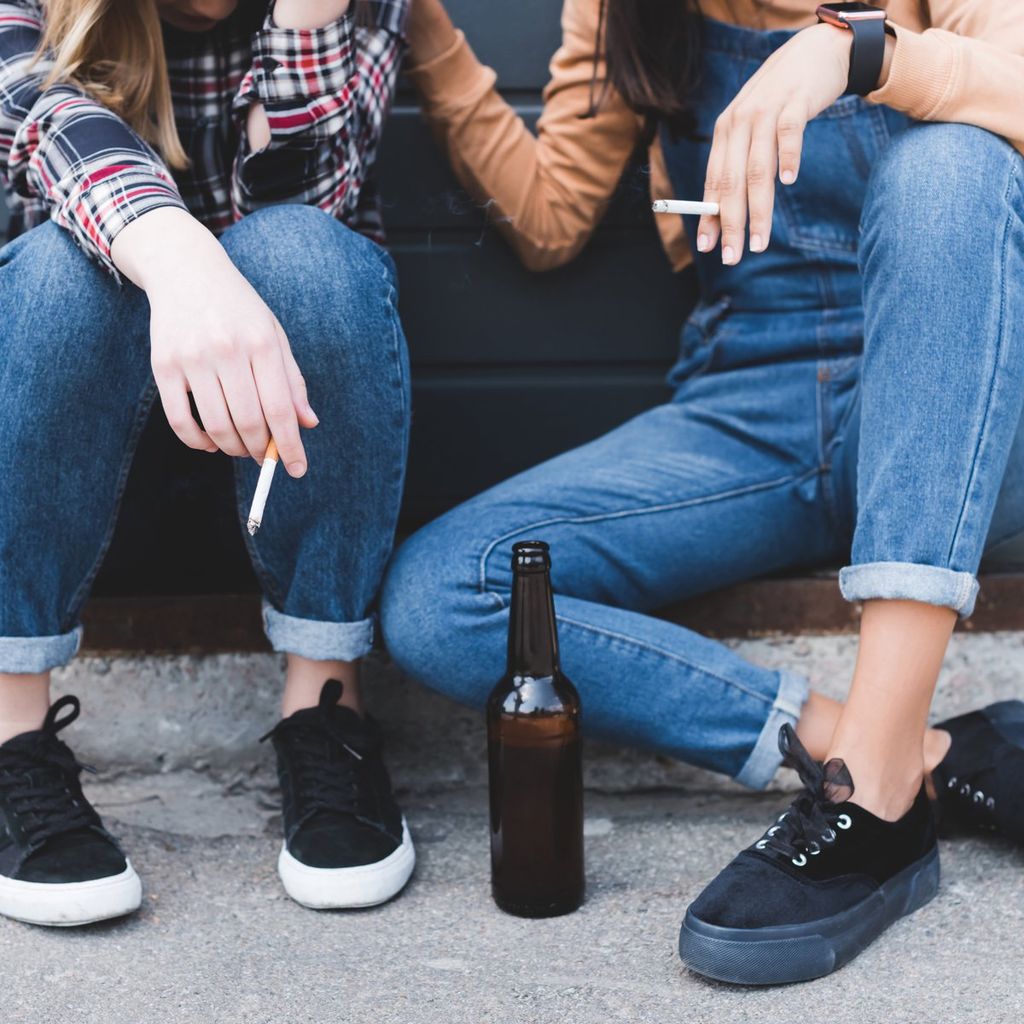 Adolescentes consumiendo alcohol en la calle.