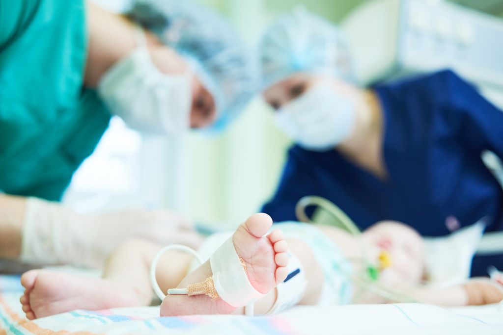 Personal médico atendiendo a un bebé en una UCI