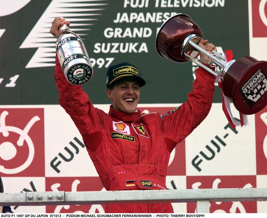 Michael Schumacher en 1997 en el Gran Premio de Japón levantando la copa de la victoria y una botella de Möet & Chandon. 