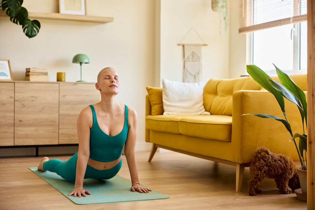 mujer con cáncer haciendo yoga en casa