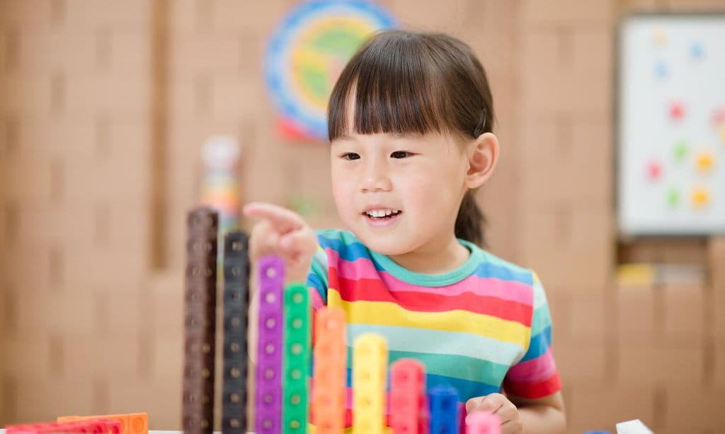young girl play number sticks for home schooling