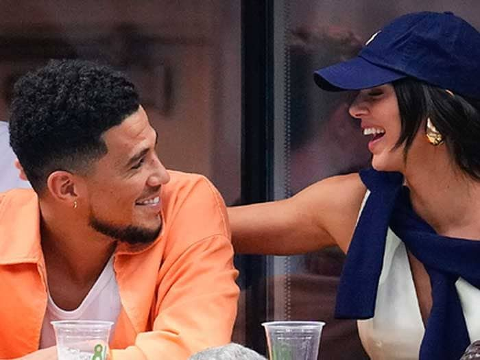 Kendall Jenner y Devin Booker en un partido de tenis riendo 