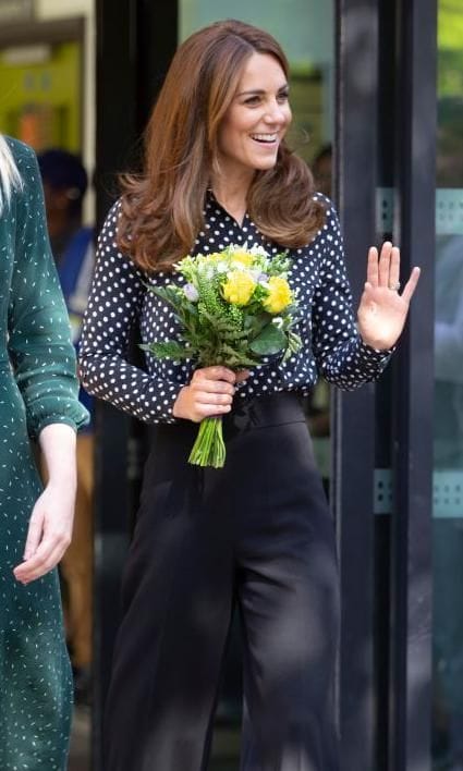 Kate Middleton lleva un look conformado por pantalones culotte negros y blusa de lunares a la par de las tendencias de moda