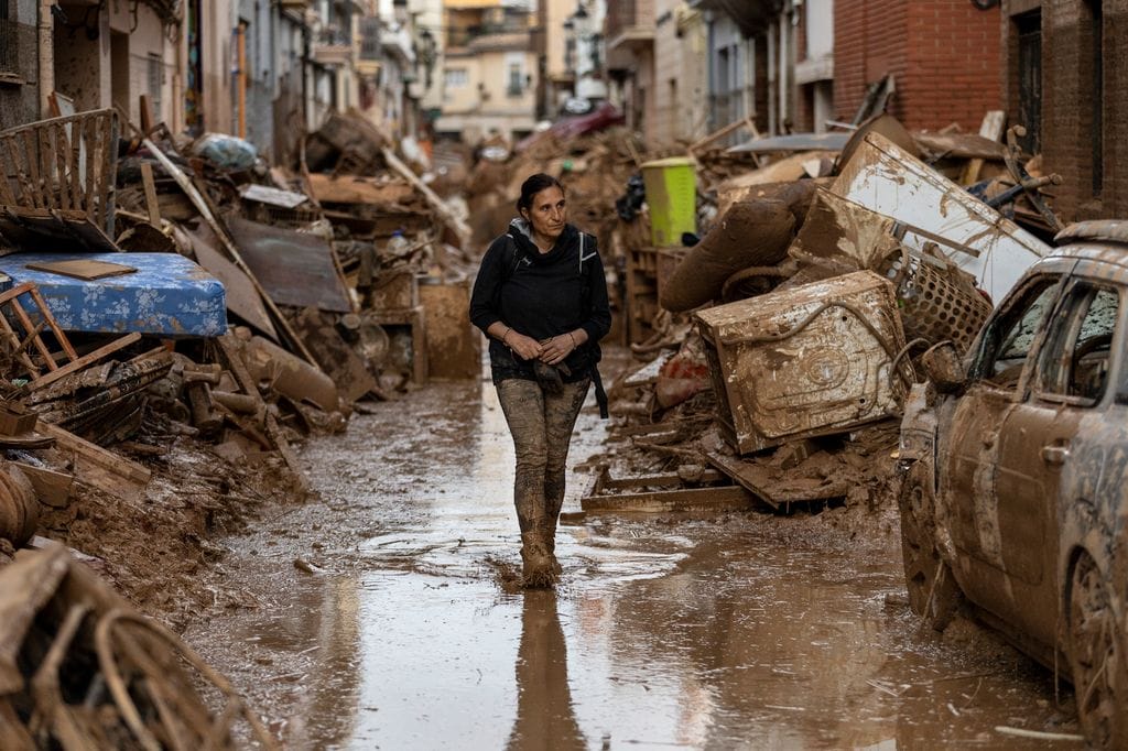 Mujer caminando por las calles anegadas de Paiporta, un pueblo afectado por la DANA en la Comunidad Valenciana