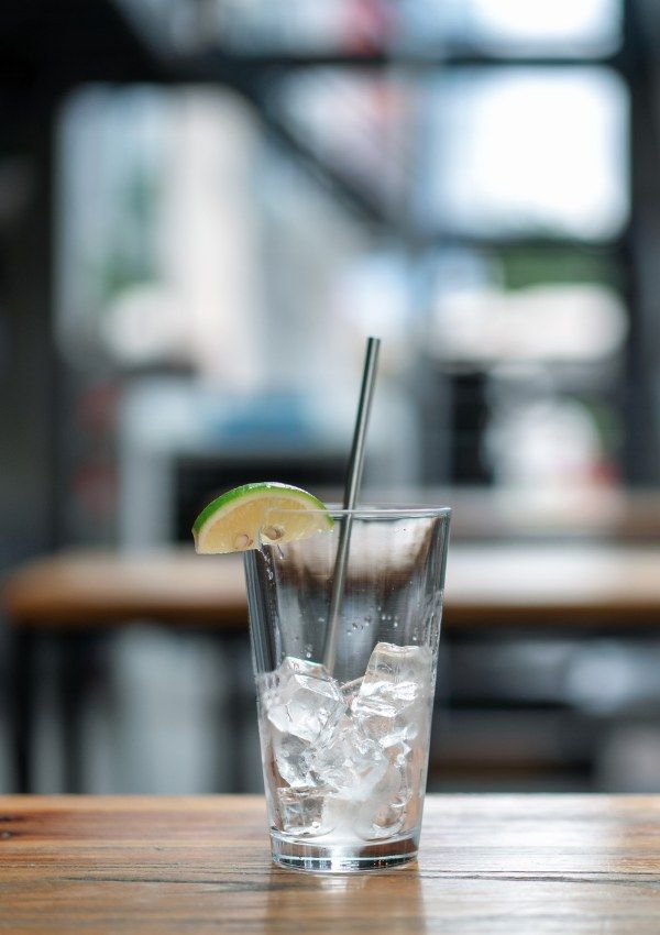 Vaso con hielo y lima sobre mesa