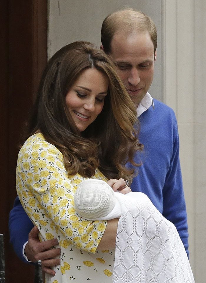 Los Duques de Cambridge con miran embelesados a su hija recién nacida durante su presentación ante los medios de comunicación
