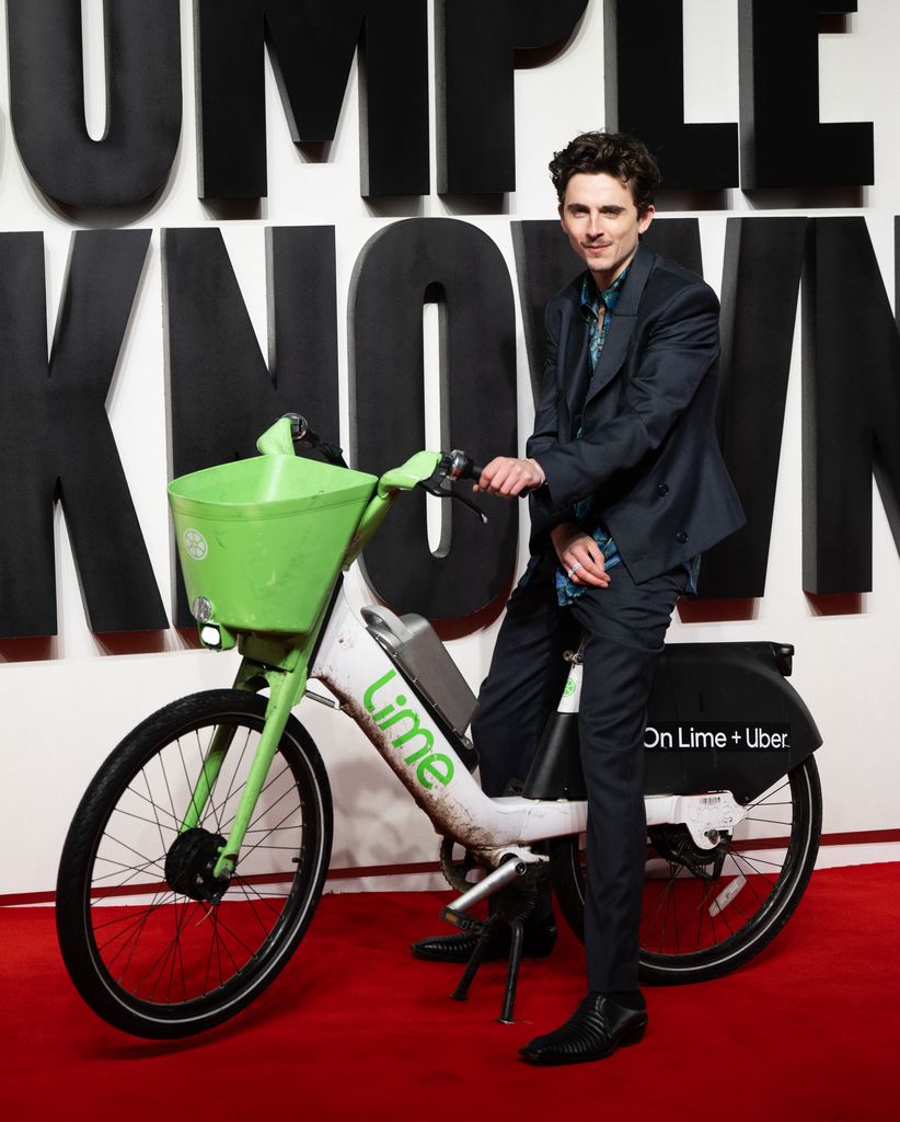 Timothée Chalamet llega a la premier de "A Complete Unknown" en Londres sobre una bicicleta