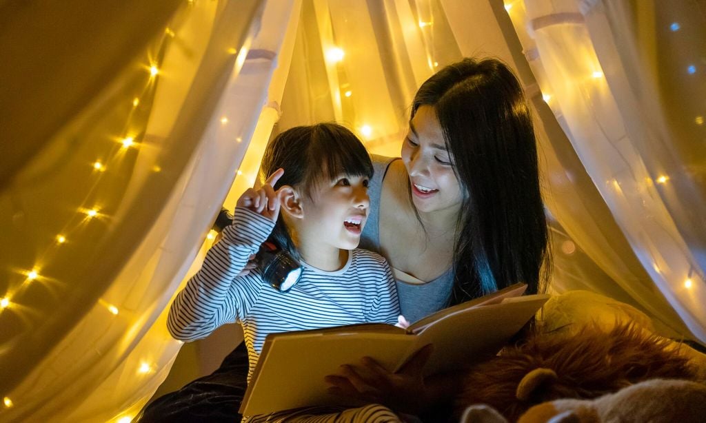 mother read fairy tale for her daughter to listen at home 