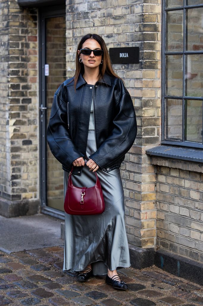 Look de Copenhagen Street Style con vestido satinado y chaqueta bomber