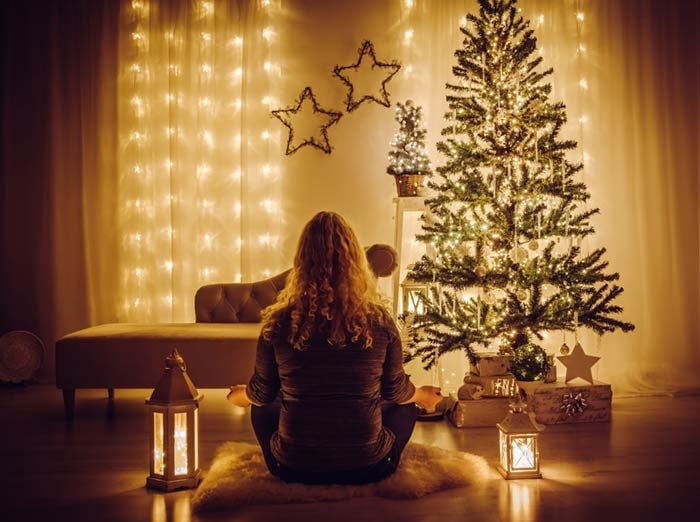 mujer meditando frente al árbol de Navidad