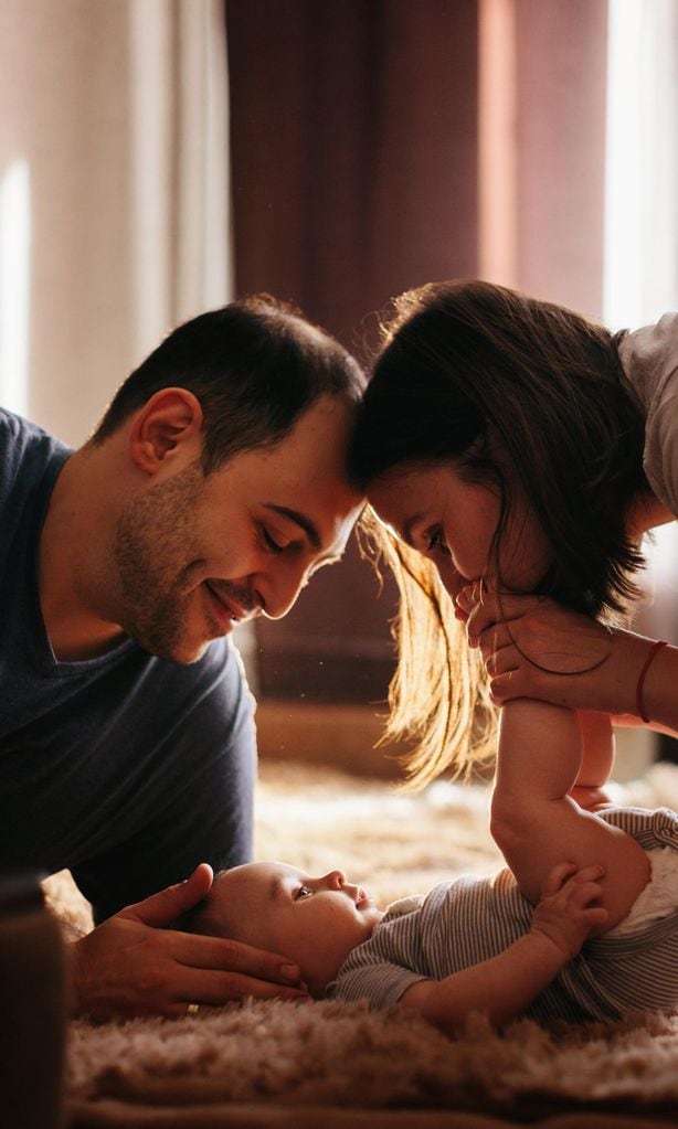 Bebé recién nacido con sus papás en casa