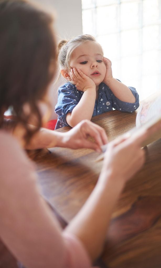 Niña con su mamá escuchando cómo le cuenta un cuento