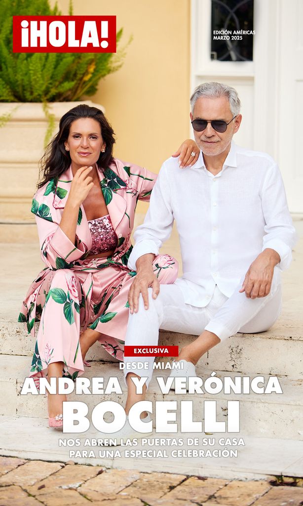 Andrea Bocelli y Verónica Bocelli sentados en los escalones exteriores, vestidos elegantemente de blanco y con atuendos florales, posando relajados y sonrientes para la edición de marzo 2025 de la revista ¡HOLA!.