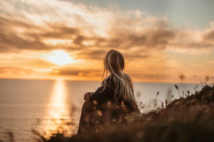 mujer viendo el atardecer