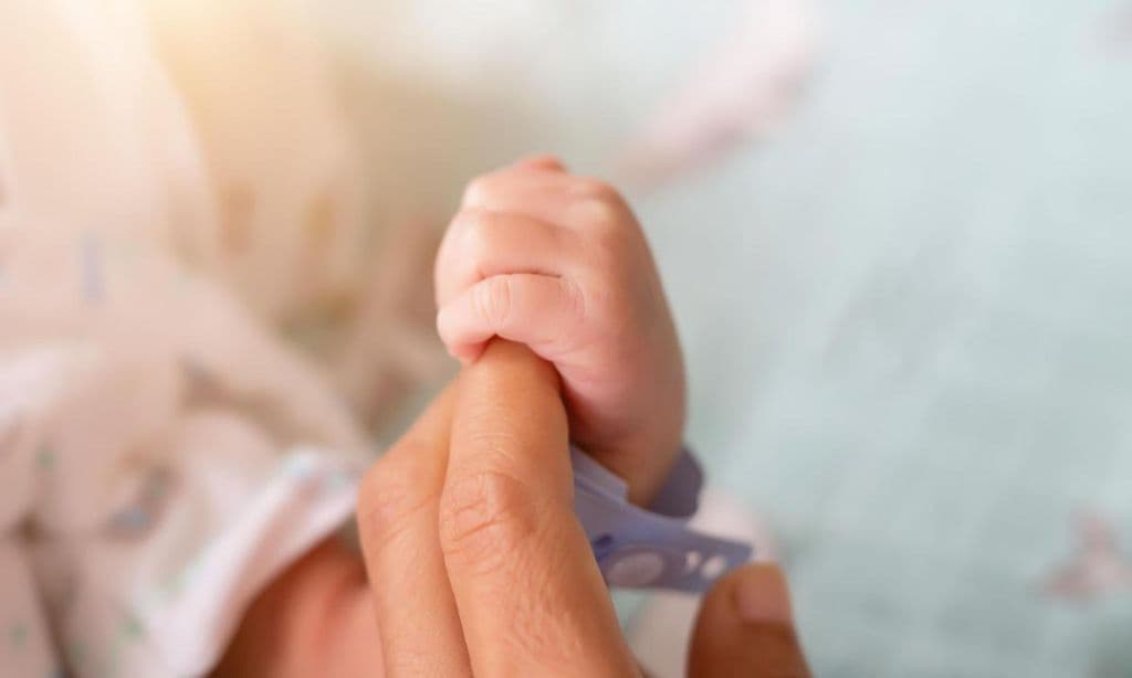 mano de beb cogiendo dedo de su mam 