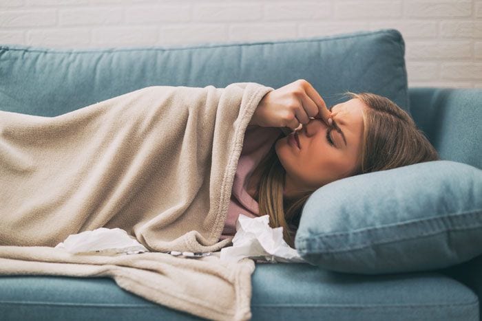 mujer en la cama con dolor de cabeza