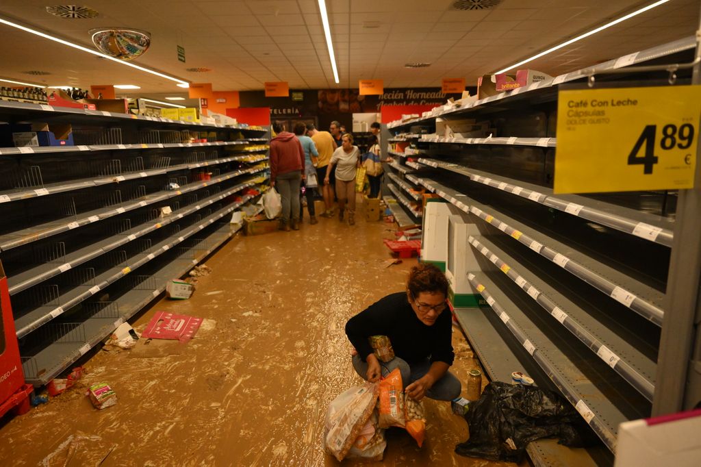 VALENCIA, SPAIN - OCTOBER 31: People collect items in mud-covered aisles at a Consum supermarket that was vandalized after flooding hit large parts of the country on October 31, 2024 in the Paiporta municipality of Valencia, Spain. By Thursday, Spanish authorities confirmed that at least 95 people had died, mostly in the Valencia region, amid the flooding that swept eastern and southern parts of the country starting on Tuesday. The intense rainfall event is known as a "cold drop" or DANA weather system. (Photo by David Ramos/Getty Images)