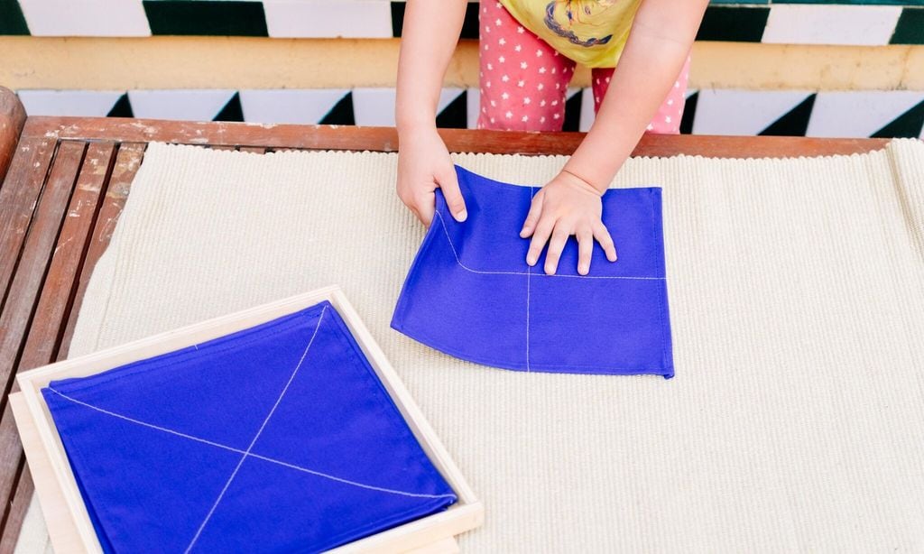 folding napkins for children is a task to improve the fine motor skills of the hands of the students of montessori schools 