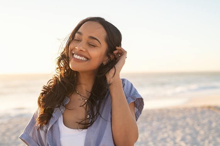 mujer feliz junto al mar