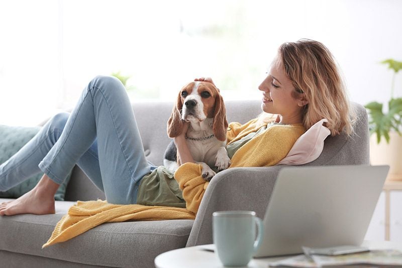 mujer en sofa abrazando perro